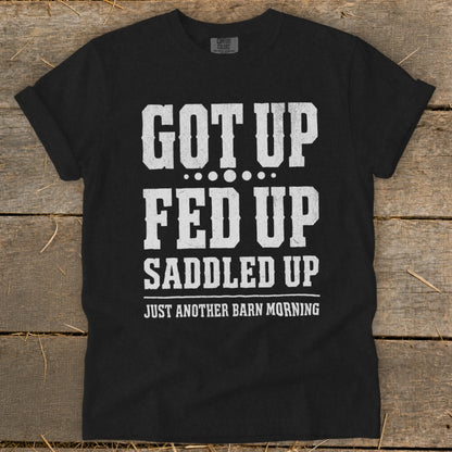 Black t-shirt with white text: "GOT UP FED UP SADDLED UP JUST ANOTHER BARN MORNING".
