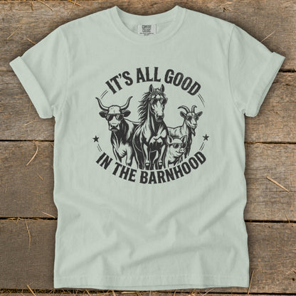 Light green t-shirt with a graphic of a cow, horse, goat, and pig wearing sunglasses. Text reads "It's All Good In The Barnhood".