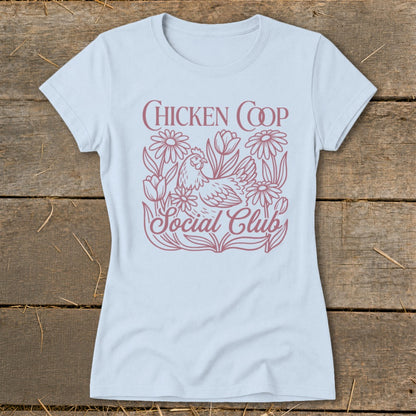 Light blue t-shirt with "CHICKEN COOP Social Club" text and chicken amongst flowers.