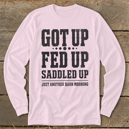 Pink long-sleeve shirt with "GOT UP FED UP SADDLED UP JUST ANOTHER BARN MORNING" text.
