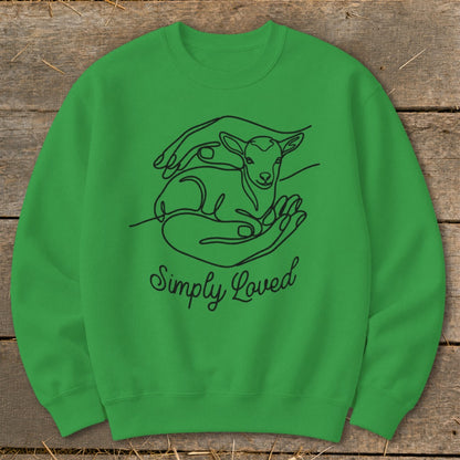 Green sweatshirt with black line art of a lamb held in hands and the words "Simply Loved."