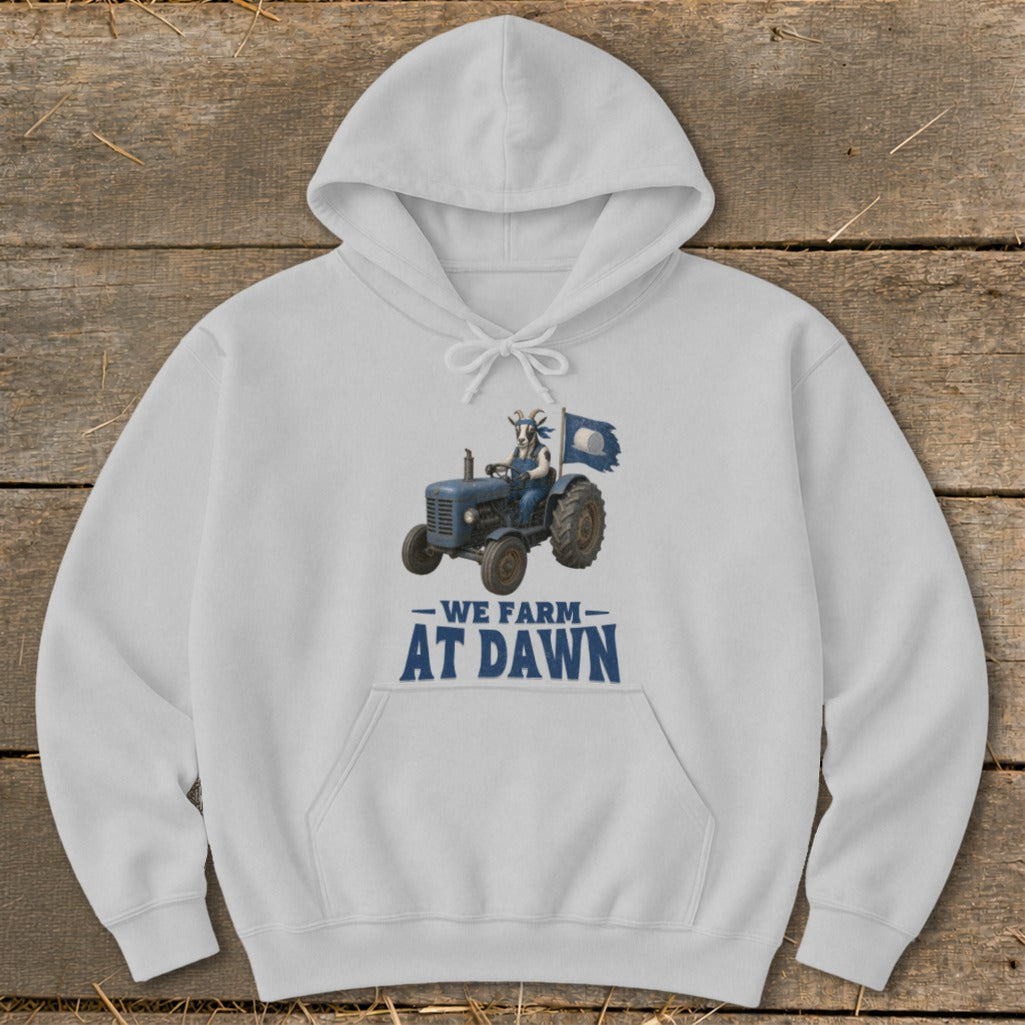 White hoodie with a graphic of a goat driving a tractor and the text "WE FARM AT DAWN".