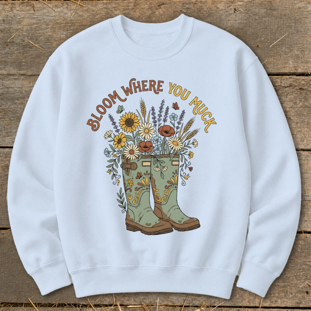 Light blue sweatshirt with "Bloom Where You Muck" and floral boots graphic.