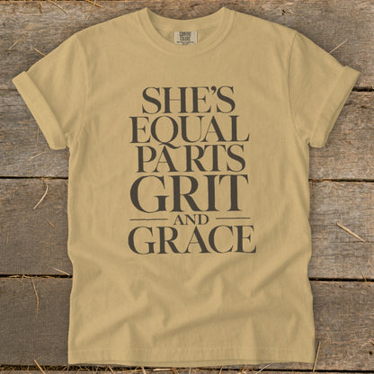 Tan Comfort Colors t-shirt with "She's Equal Parts Grit and Grace" printed in dark grey text.