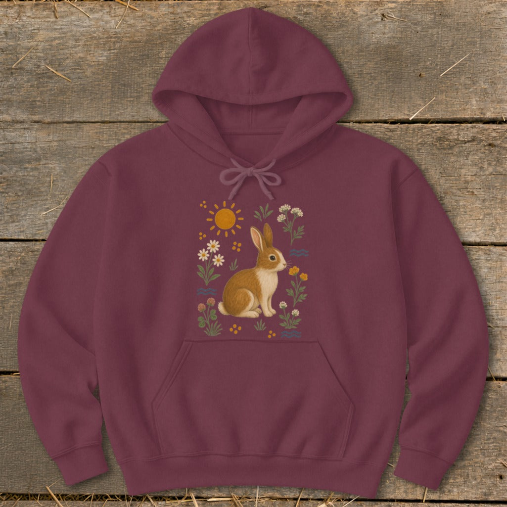 Maroon hoodie with a whimsical graphic of a rabbit surrounded by flowers and a sun.