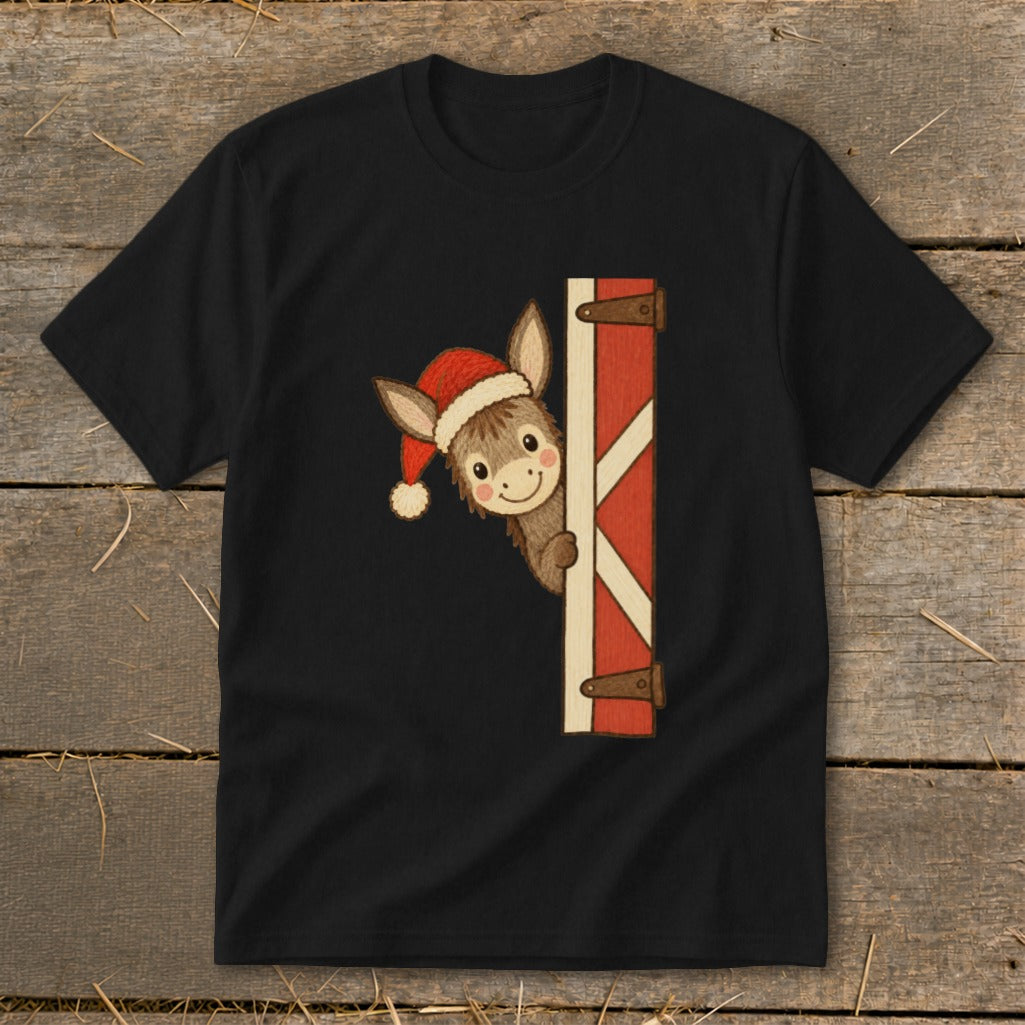 Donkey wearing a Santa hat peeking from behind a rustic barn door.