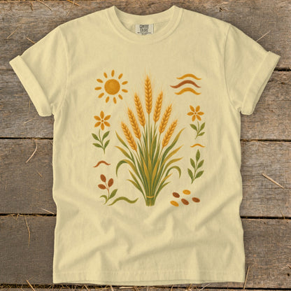 Yellow t-shirt with wheat stalks, sun, flowers, and abstract lines design.