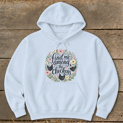 Light blue hoodie with floral wreath and text "Find me among the chickens" with chickens.