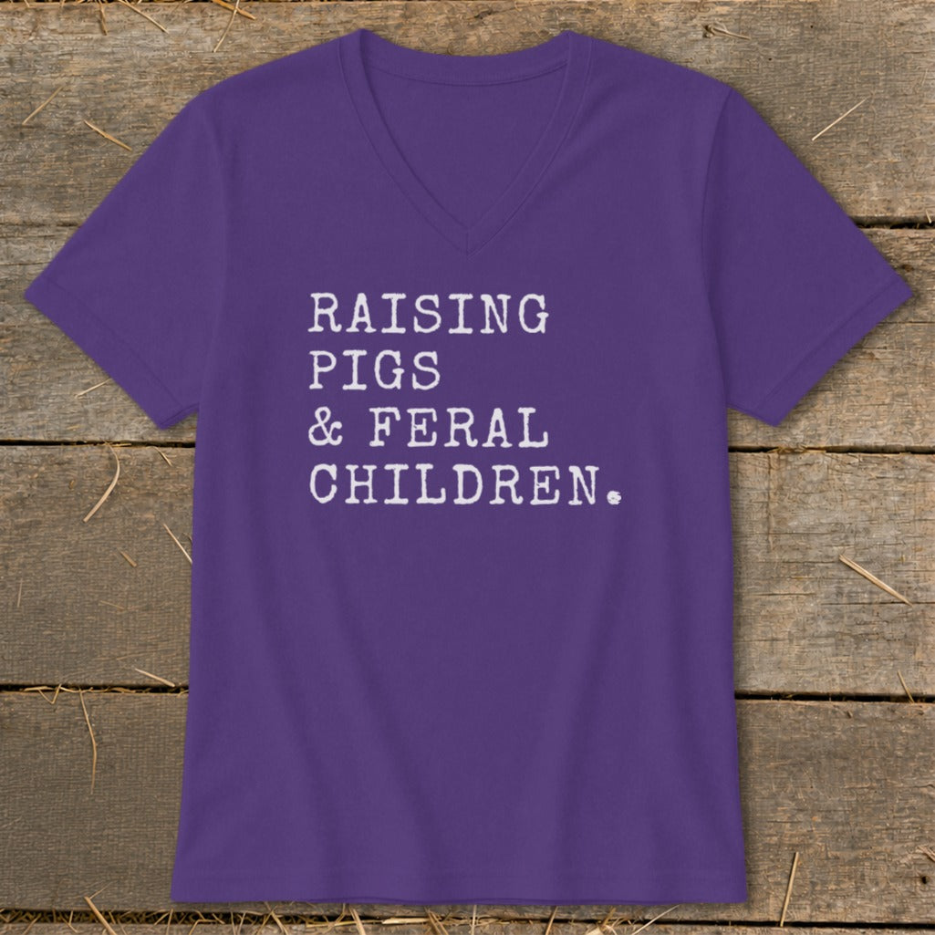 Purple v-neck t-shirt with white text reading "Raising Pigs & Feral Children."
