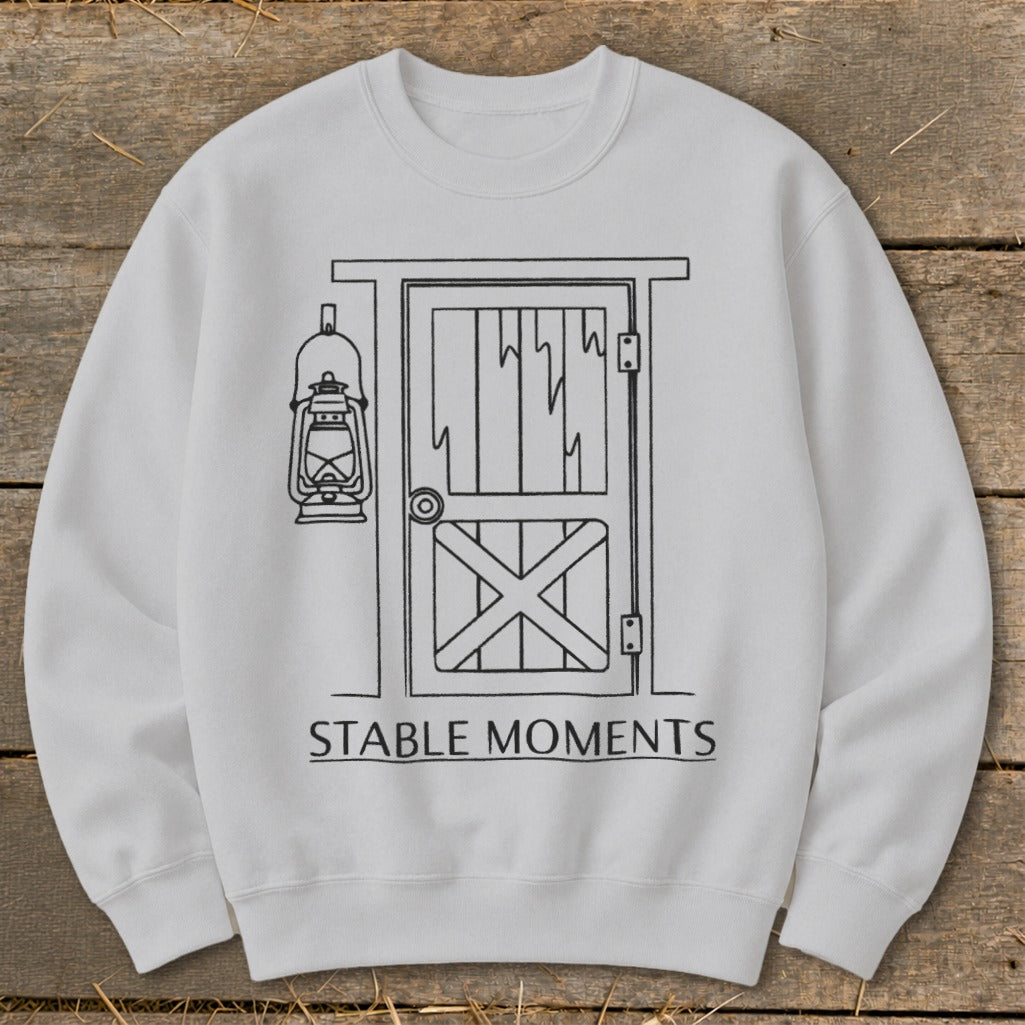 White sweatshirt with line drawing of stable door and lantern, text "STABLE MOMENTS".