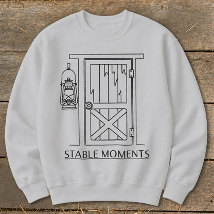 White sweatshirt with line drawing of stable door and lantern, text "STABLE MOMENTS".