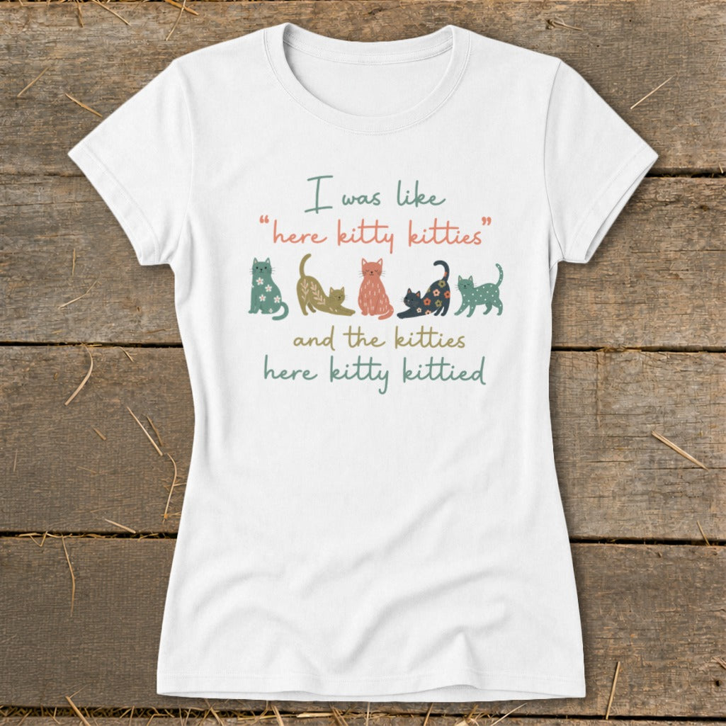 White t-shirt with colorful cats and text: "I was like 'here kitty kitties'" and "and the kitties here kitty kittied".
