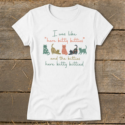 White t-shirt with colorful cats and text: "I was like 'here kitty kitties'" and "and the kitties here kitty kittied".