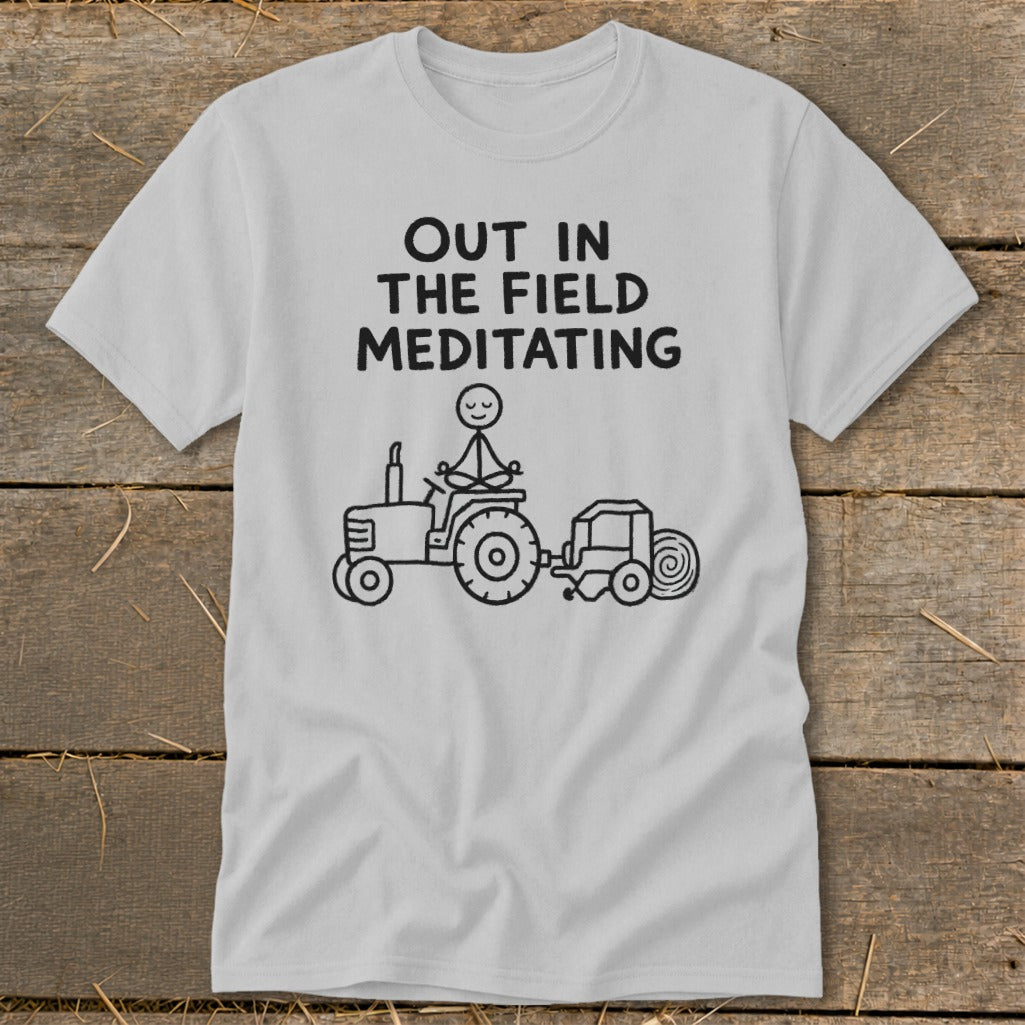 Light gray t-shirt with text and illustration of a person meditating on a tractor.