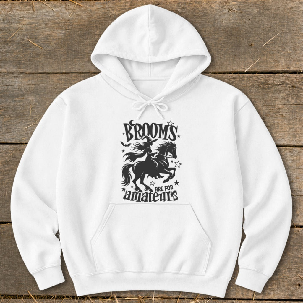 White hoodie with black graphic of witch riding horse, "BROOMS ARE FOR amateurs."