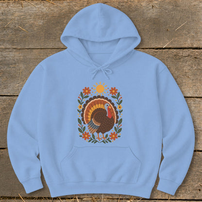 Light blue hoodie with a Thanksgiving turkey design featuring floral accents and a sun.