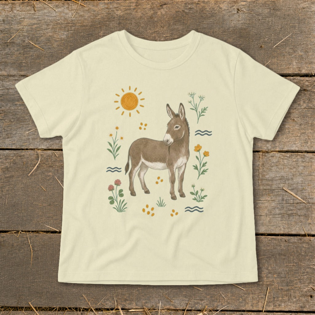 Light yellow t-shirt with a drawing of a donkey surrounded by flowers, sun, and wavy lines.