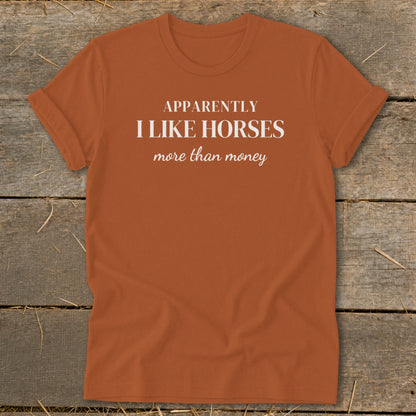 Orange t-shirt with "Apparently I like horses more than money" text in white.