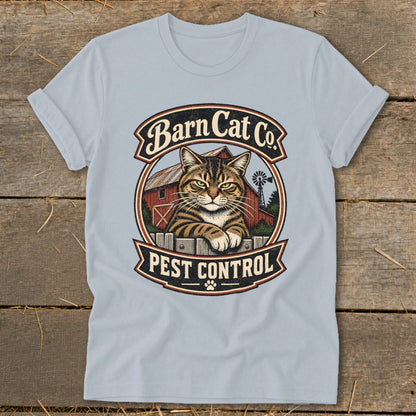 Light blue t-shirt featuring a circular graphic with a tabby cat, barn, windmill, and text reading Barn Cat Co Pest Control.
