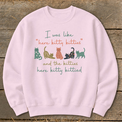 Pink sweatshirt with illustrated cats and text "I was like 'here kitty kitties' and the kitties here kitty kittied".