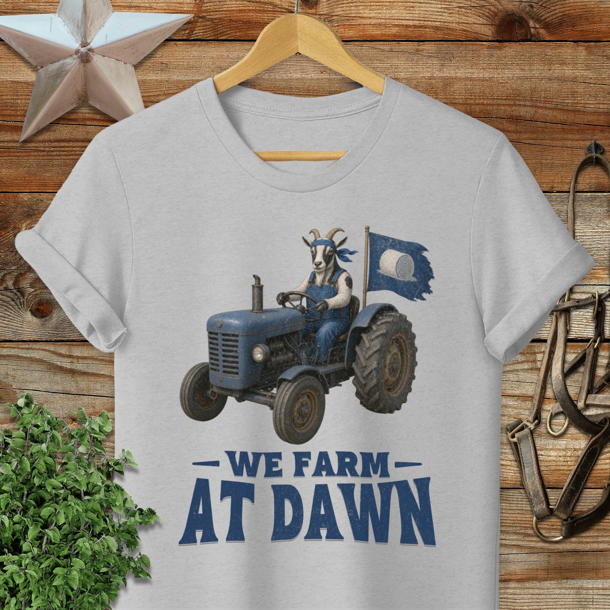Blue tractor with a goat driver and "We Farm At Dawn" text.