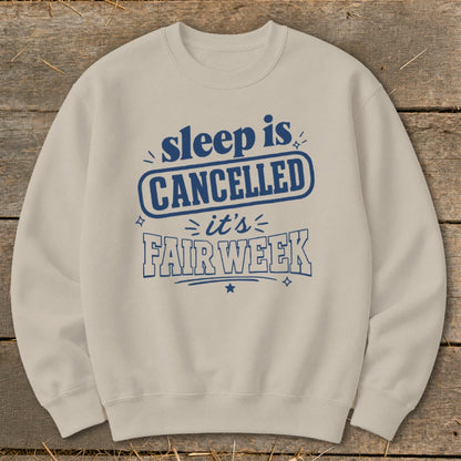 Light tan crewneck sweatshirt with blue text reading "sleep is CANCELLED it's FAIR WEEK".
