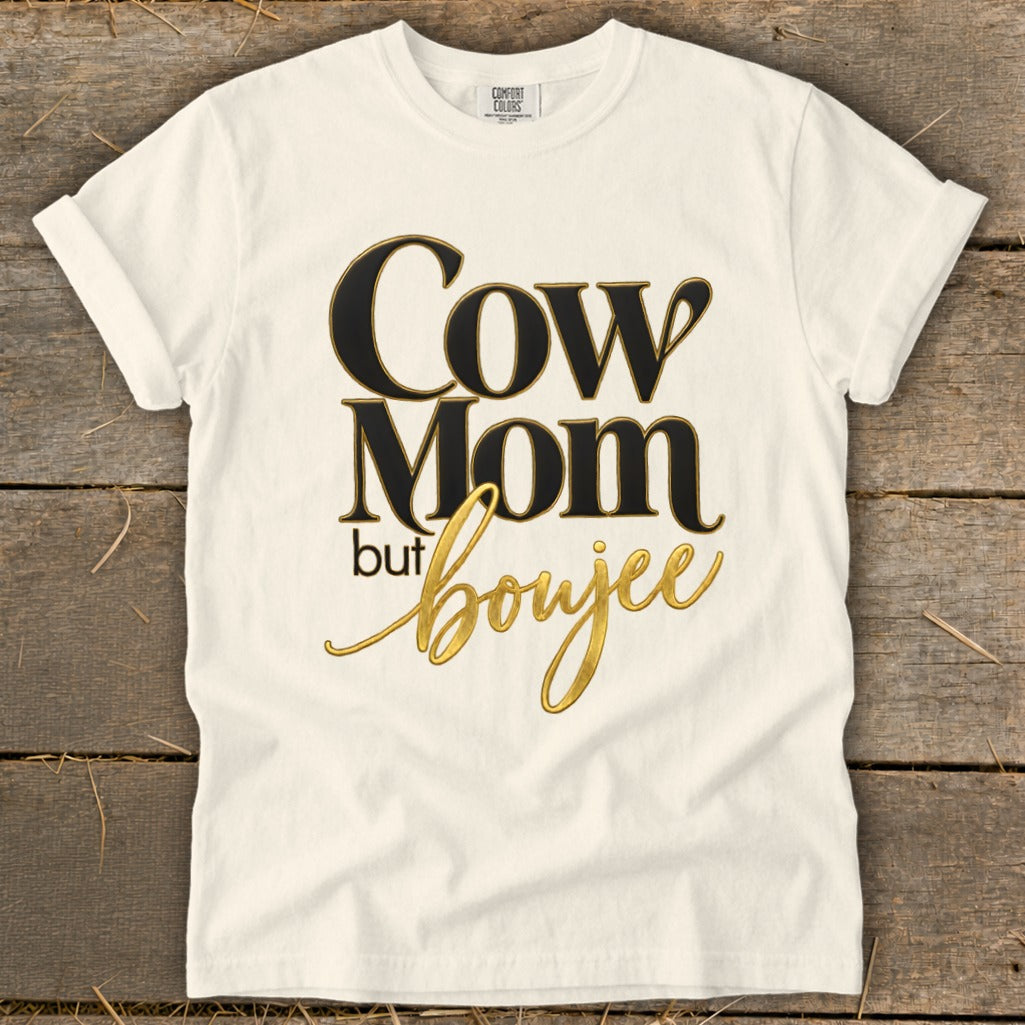 White t-shirt with black and gold text reading "Cow Mom but boujee".