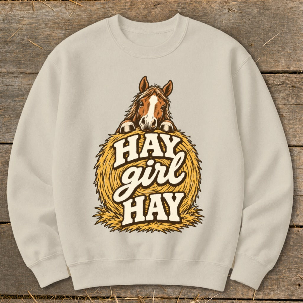 Light beige sweatshirt with horse peeking over hay bale graphic and "Hay girl hay" text.