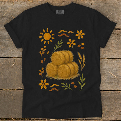 Black t-shirt with stacked hay bales and fall-themed graphic elements.