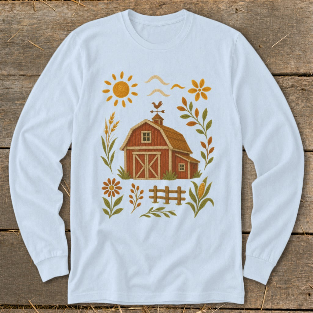 White long-sleeve shirt with embroidered farm scene featuring a red barn, sun, and flowers.