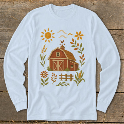 White long-sleeve shirt with embroidered farm scene featuring a red barn, sun, and flowers.