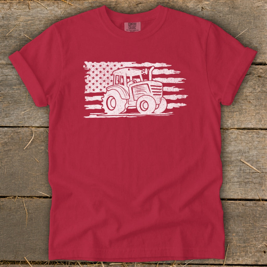 Red t-shirt with a white tractor graphic superimposed on an American flag design.