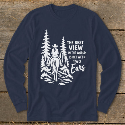 A dark blue long-sleeve t-shirt features a white graphic of a horseback rider in the woods with text reading The best view in the world is between two ears.