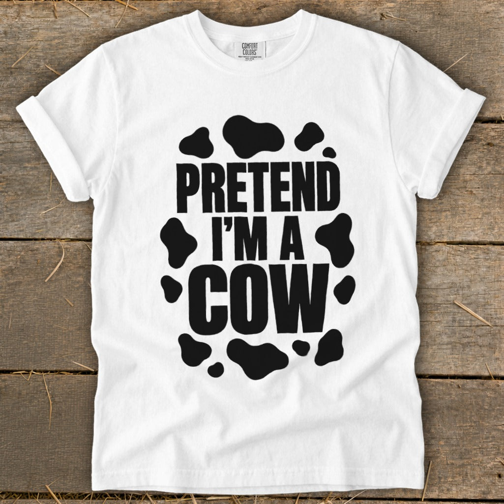 White t-shirt with black text "Pretend I'm a Cow" and cow spots.