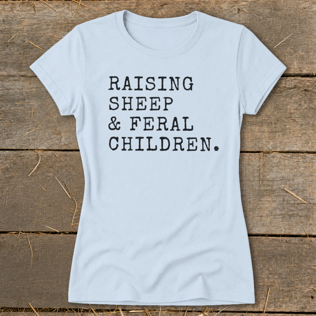 Light blue t-shirt with black text "RAISING SHEEP & FERAL CHILDREN."