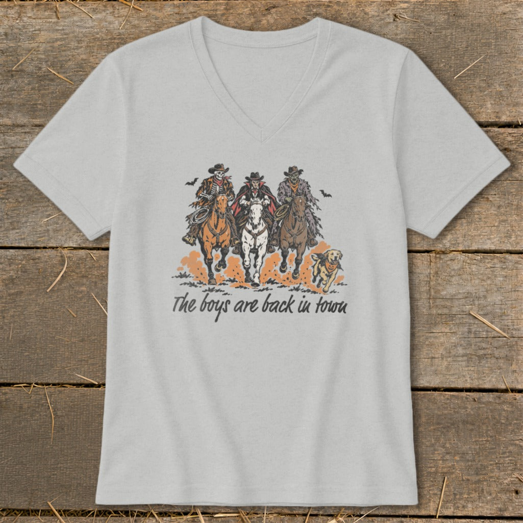 Skeleton, vampire, and zombie cowboys ride horses with a dog, text reads "The boys are back in town".