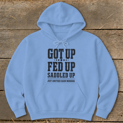 Light blue hoodie with black text reading "Got Up, Fed Up, Saddled Up, Just Another Barn Morning".