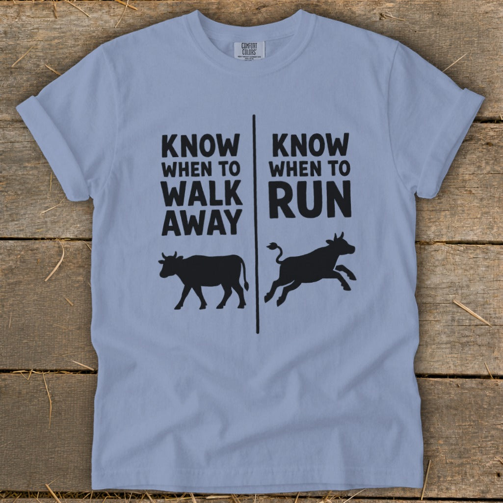 Light blue t-shirt with black text and cow silhouettes.