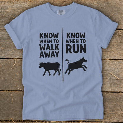 Light blue t-shirt with black text and cow silhouettes.