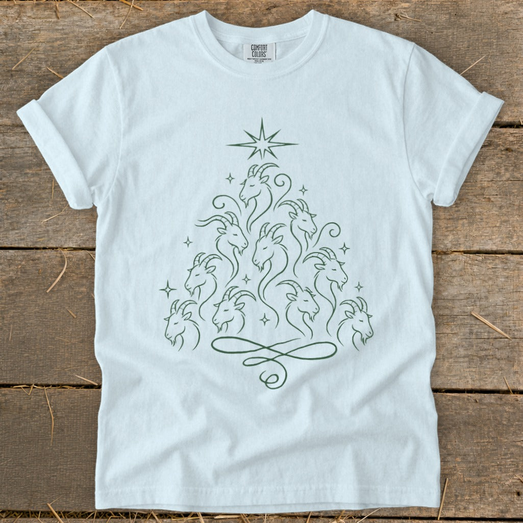 White t-shirt with a green line drawing of goats arranged in a Christmas tree shape.