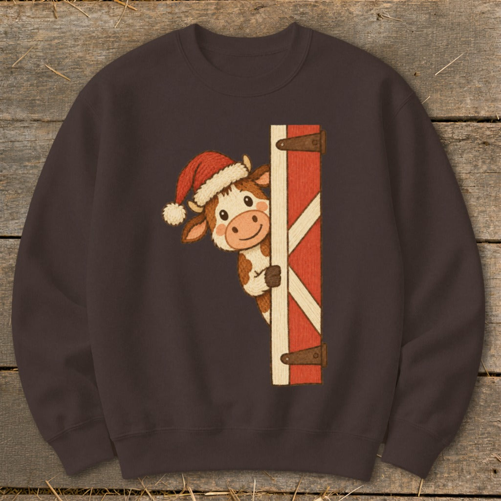 Cartoon cow wearing a Santa hat peeking from behind a red barn door.
