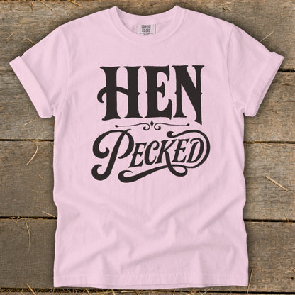 Pink t-shirt with black text "HEN PECKED" and "COMFORT COLORS" label.