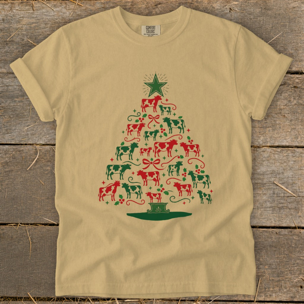 Tan t-shirt with a Christmas tree made of red and green cows, bows, and holly.