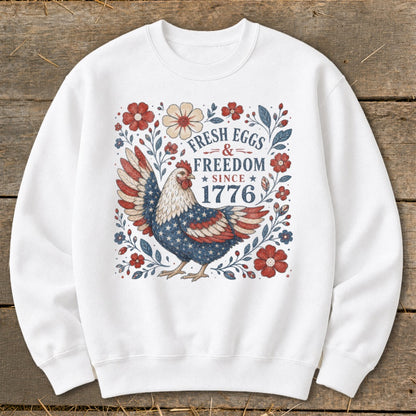 White sweatshirt with patriotic chicken and text "Fresh Eggs & Freedom Since 1776".