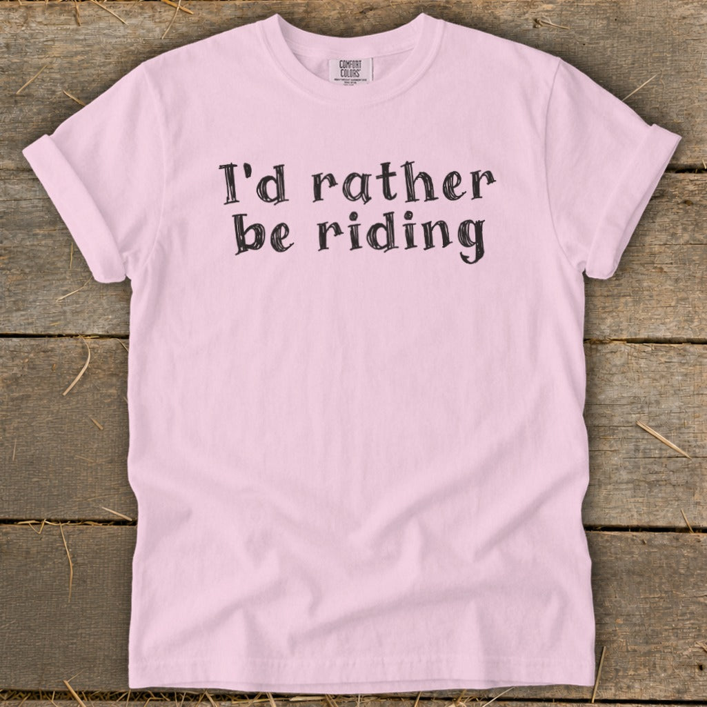Pink t-shirt with black text that reads "I'd rather be riding."