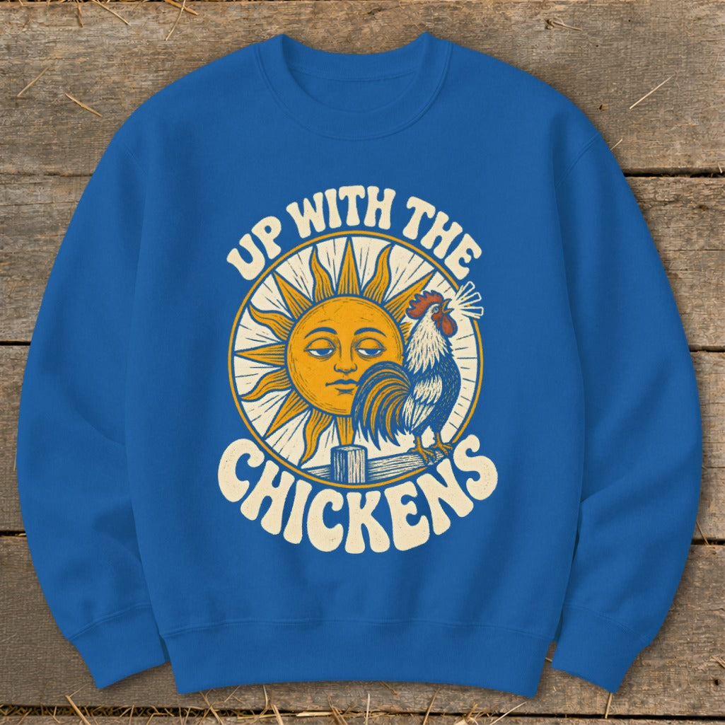 A royal blue crewneck sweatshirt featuring a graphic of a rooster and sun with the text Up With The Chickens.