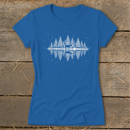 Blue t-shirt with white graphic of pine trees, a deer, and snowflakes reflecting in water.