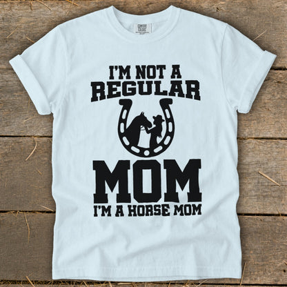White t-shirt with "I'm Not a Regular Mom, I'm a Horse Mom" text and horseshoe graphic.