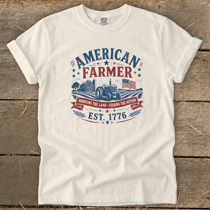White t-shirt with "American Farmer" graphic, tractor, barn, flag, and "Est. 1776".