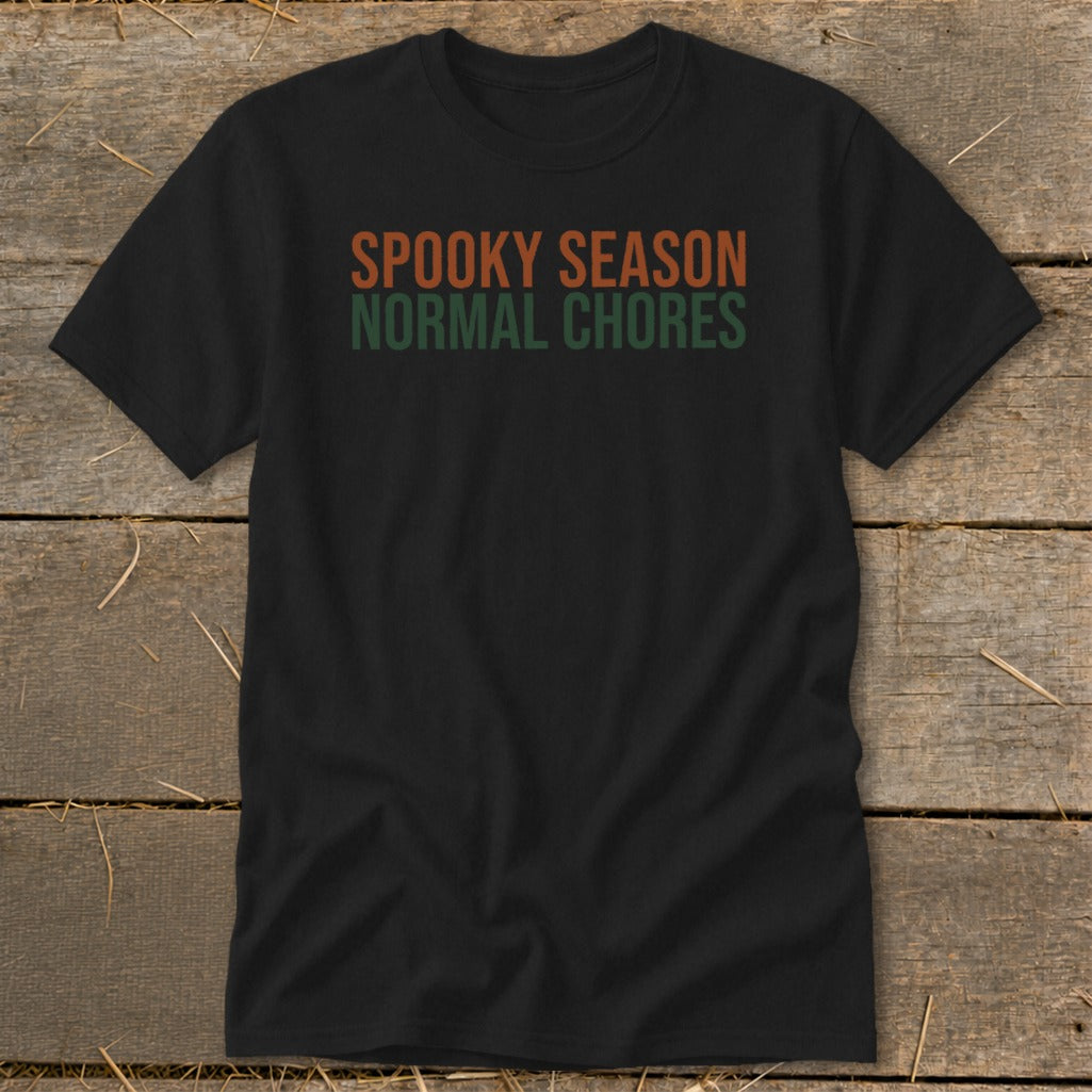 Black t-shirt with orange and green text reading "SPOOKY SEASON NORMAL CHORES".